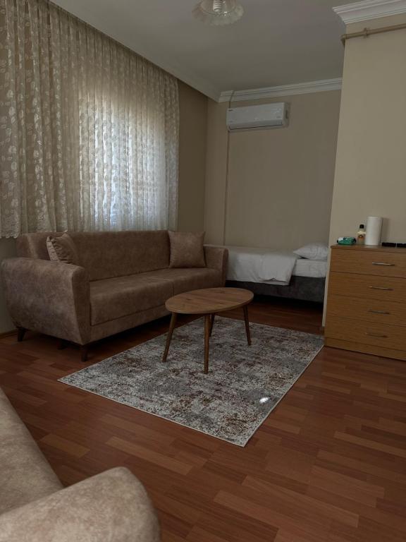 BEŞ YILDIZ APART في طرابزون: غرفة معيشة مع أريكة وطاولة