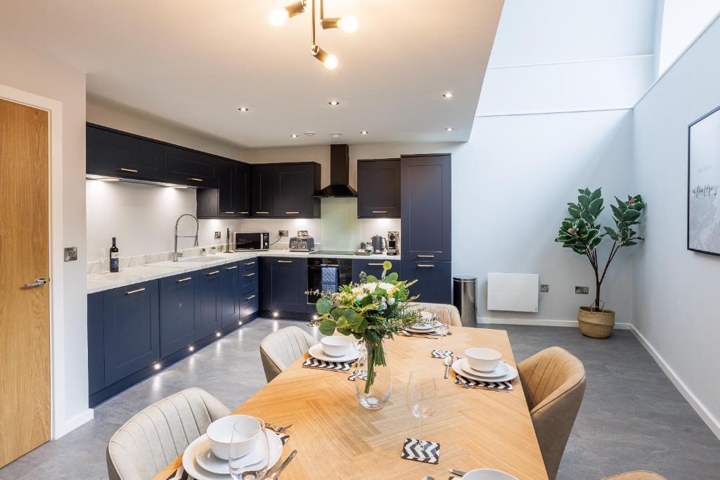 uma cozinha e sala de jantar com uma mesa de madeira e cadeiras em Luxury apartment 5 min to city centre*free parking em Newcastle upon Tyne