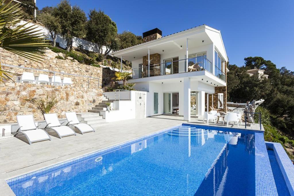 a villa with a swimming pool and a house at Villa Pacifica in Santa Cristina d'Aro