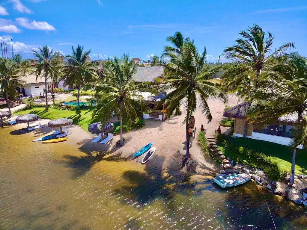 Moriá Eco Lodge في إيكاري: اطلالة جوية على شاطئ فيه نخيل وقوارب