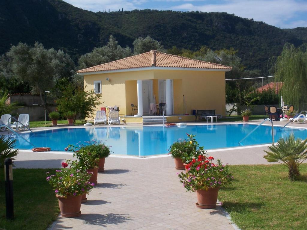 a villa with a swimming pool in front of a house at Iliaktida Studio-Villas in Lefkada Town