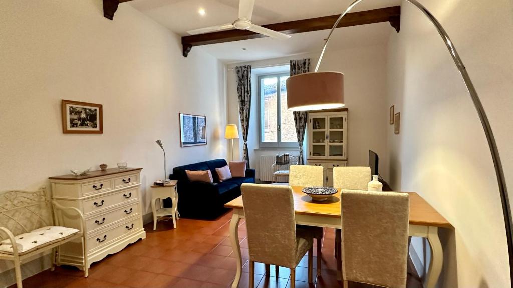 een eetkamer en een woonkamer met een tafel en stoelen bij Dreaming Assisi Apartment in Assisi