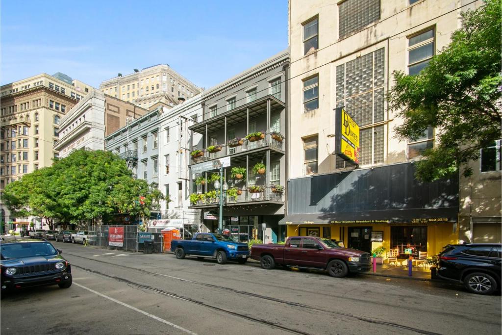une rue de la ville avec des voitures garées devant un bâtiment dans l'établissement Roami at Bourbon Place, à La Nouvelle-Orléans