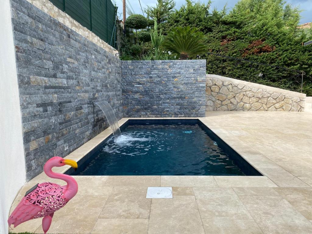 a swimming pool with a pink flamingo next to a wall at Villa Frescati in Vence