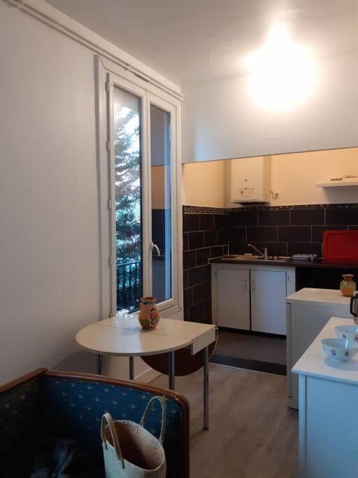 une petite cuisine avec une table et une table sidx sidx sidx dans l'établissement Appartement 2 chambres à Noisy le grand, à Noisy-le-Grand