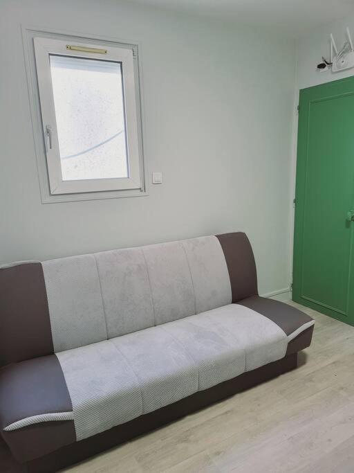 kanapę siedzącą w pokoju z oknem w obiekcie Appartement proche St denis "appart 3" w mieście Pierrefitte-sur-Seine