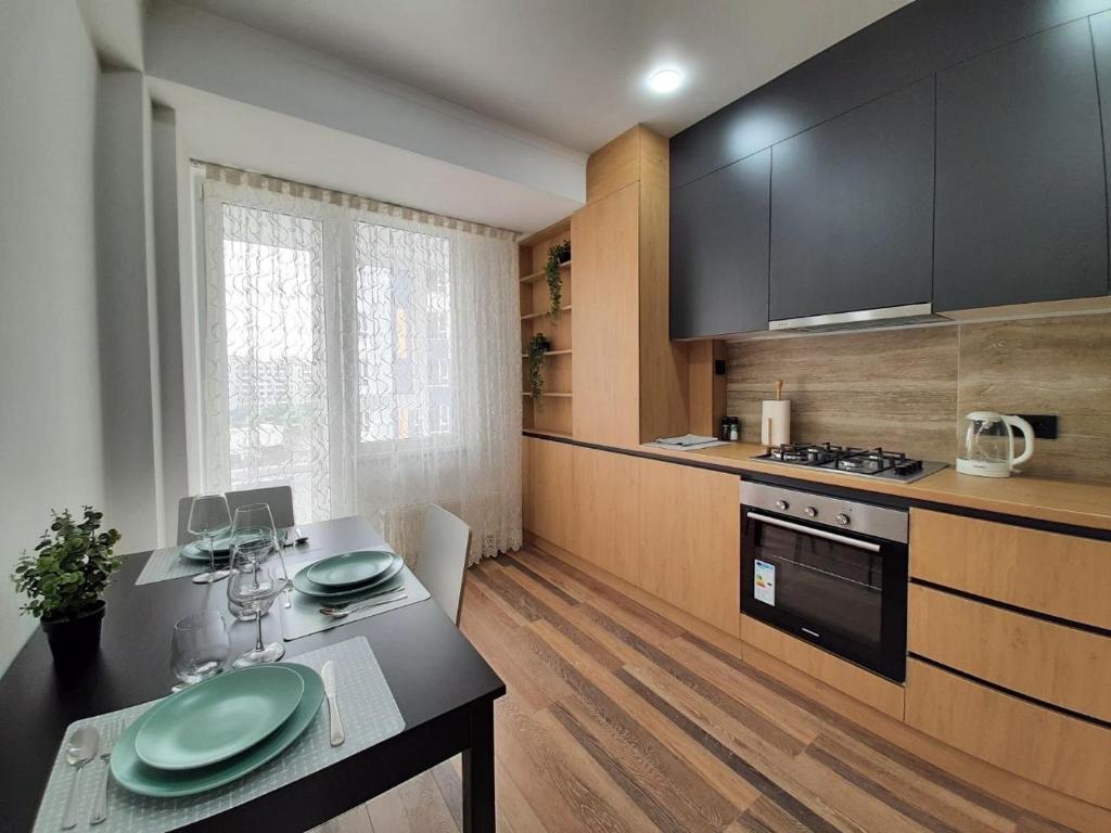 a kitchen with a table with green plates on it at Modern Apartment Near Airport in Chişinău