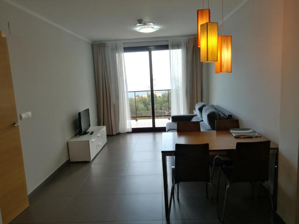 a living room with a table and a couch at Aparthotel El Faro in Cullera