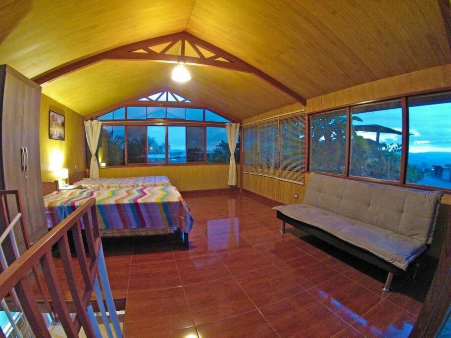 ein Schlafzimmer mit einem Bett, einem Sofa und Fenstern in der Unterkunft Casita Grau 2! Naturaleza y confort con Agua caliente,cocina y frigobar in Tarapoto