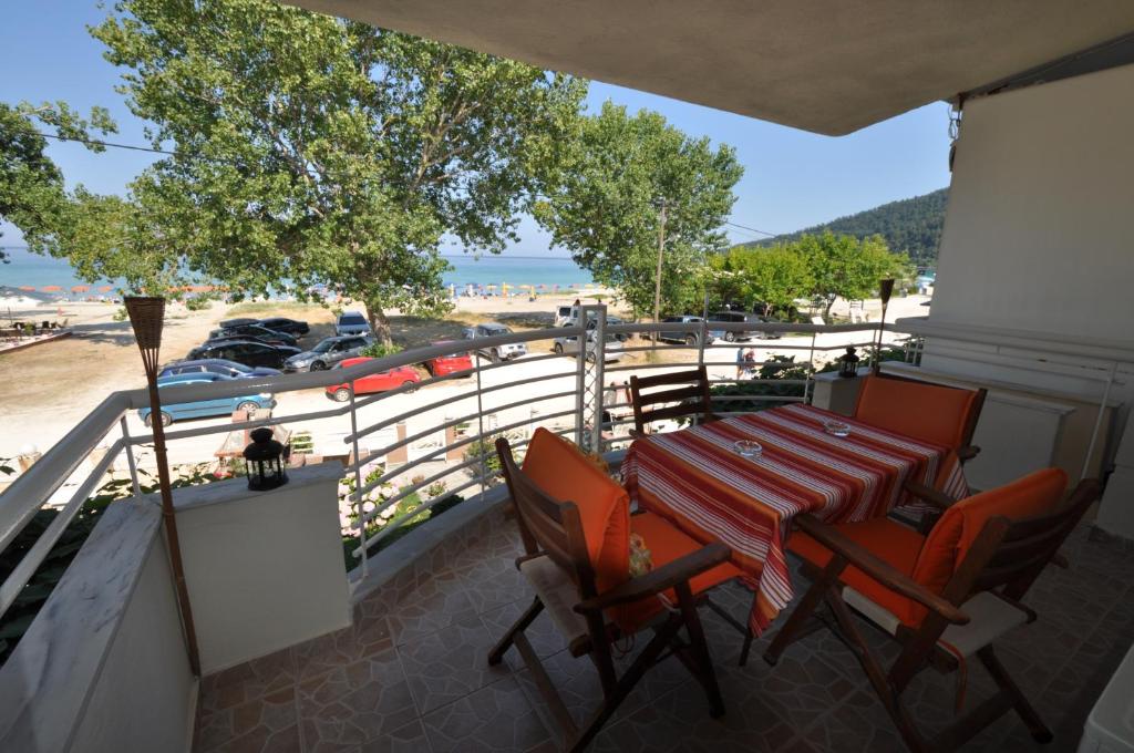 a table and chairs on a balcony with a view of the beach at Studios Giannakis in Chrysi Ammoudia