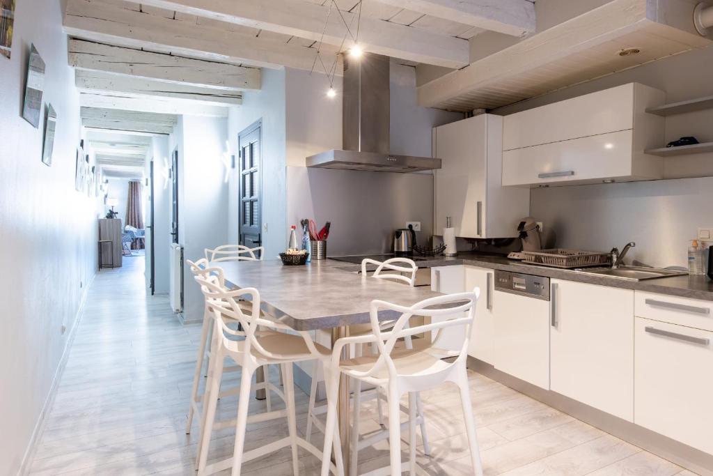 cocina con mesa de madera y sillas blancas en FITZ ROY Annecy Rent Lodge en Annecy