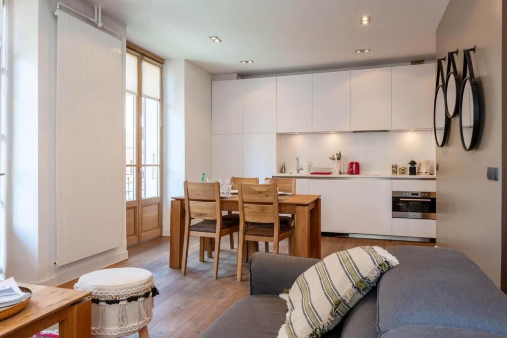 un salon et une cuisine avec un canapé et une table dans l'établissement ANNAPURNA Annecy Rent Lodge, à Annecy