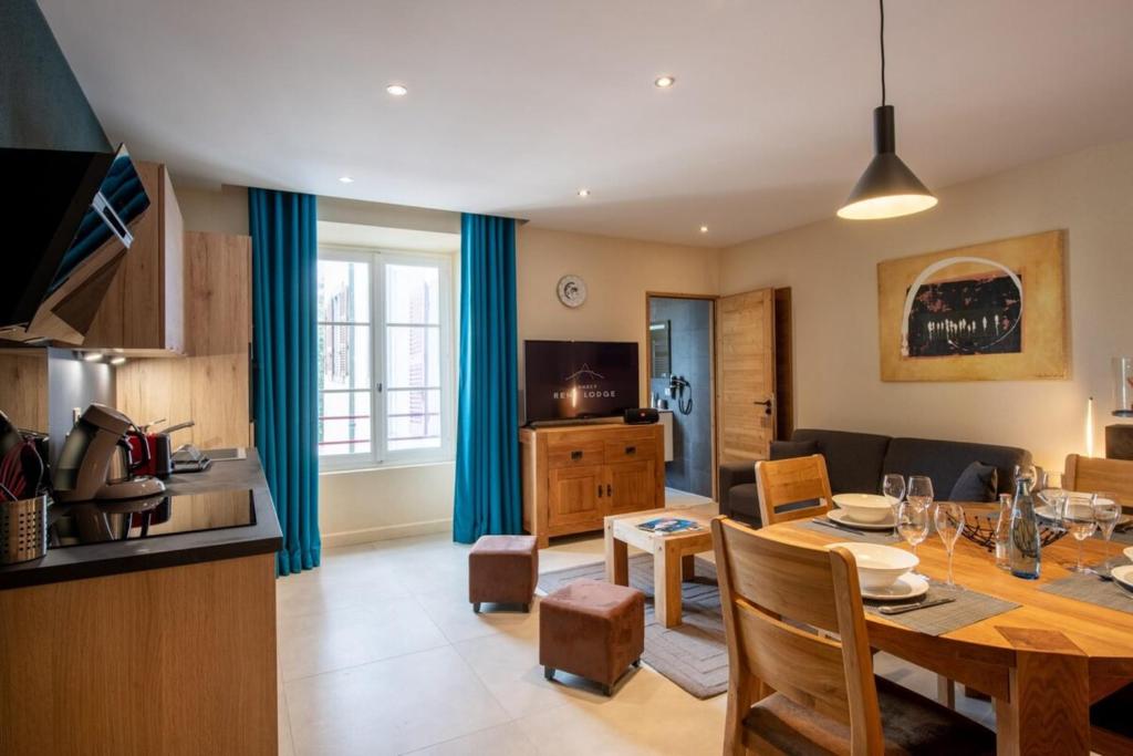 eine Küche und ein Wohnzimmer mit einem Tisch und einem Esszimmer in der Unterkunft APPENNINS Annecy Rent Lodge in Annecy