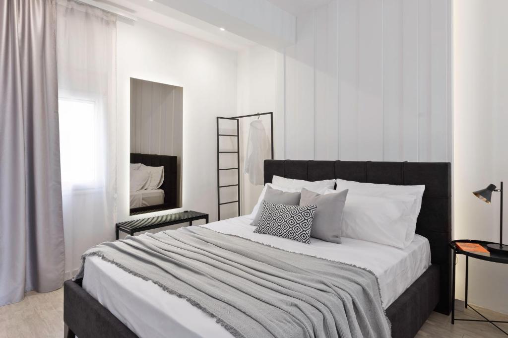 um quarto branco com uma cama grande e almofadas brancas em El mare em Ierápetra