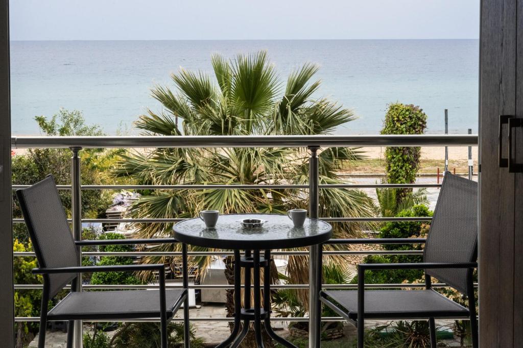 una mesa en un balcón con vistas al océano en Nikolaidis Apartments, en Nea Plagia