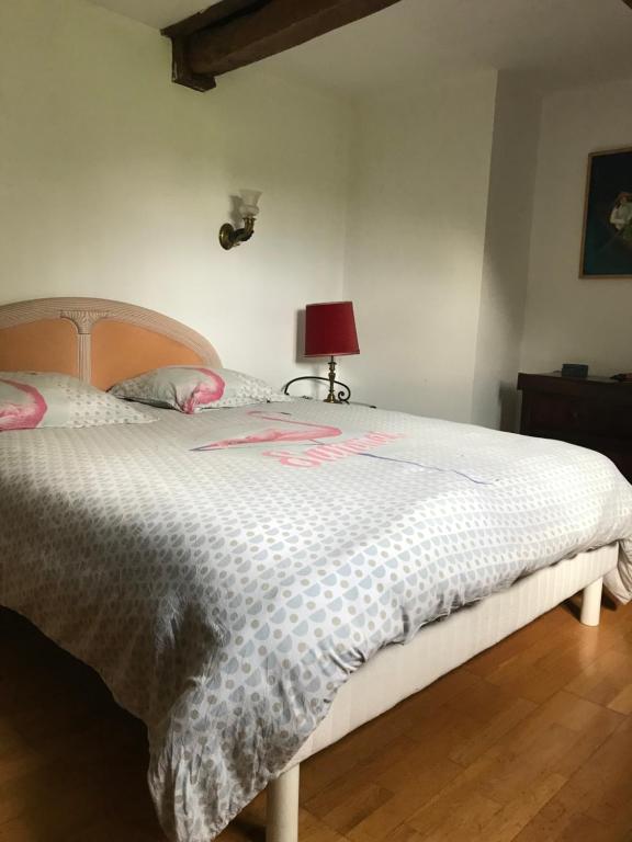 1 dormitorio con 1 cama con edredón blanco en Ancien moulin du 18 ieme en Assé-le-Riboul