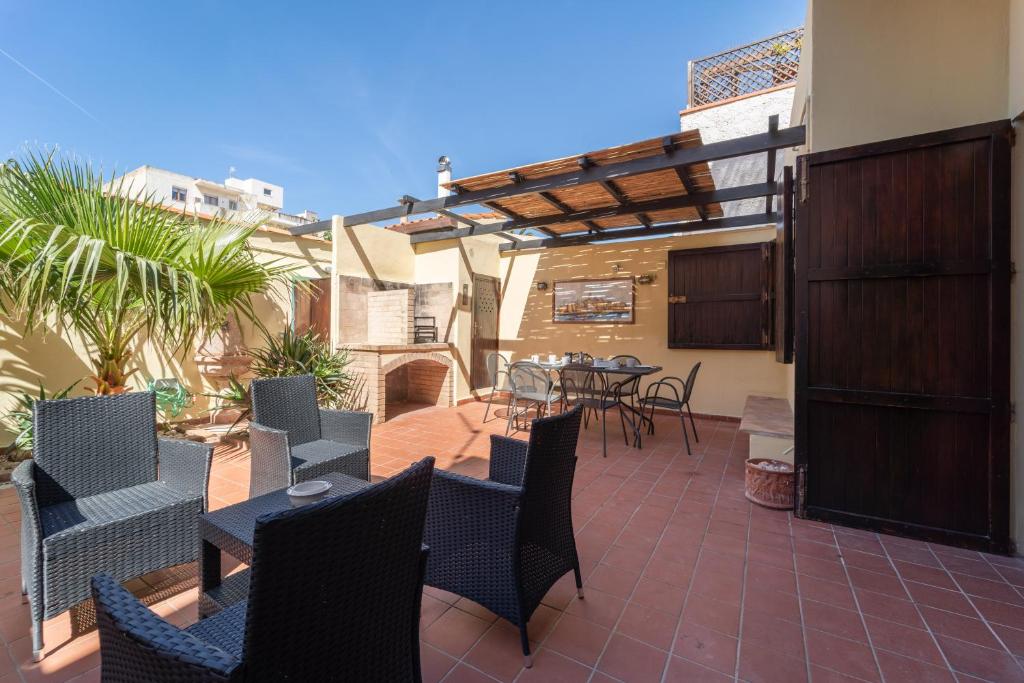 eine Terrasse mit einem Tisch und Stühlen sowie einem Tisch und einem Chaiselongue in der Unterkunft Claudia's home 2 in Alghero