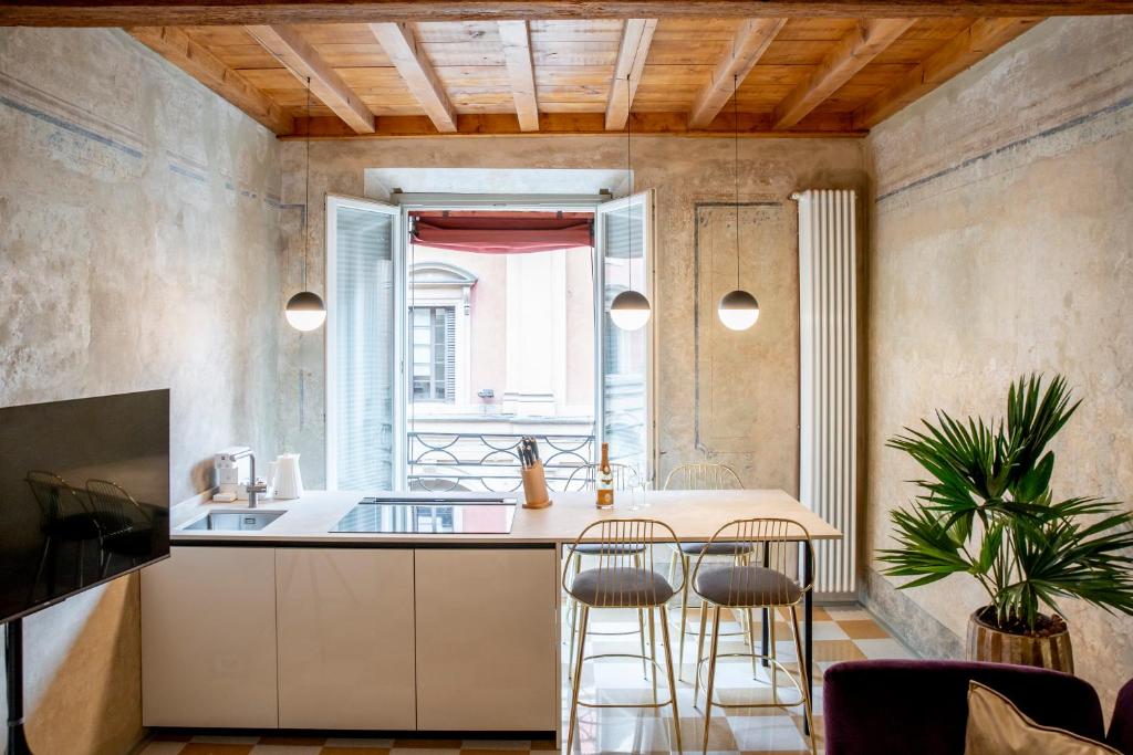 a kitchen with a counter and stools in a room at Palazzo Scappi Gardi Luxury Apartments in Bologna
