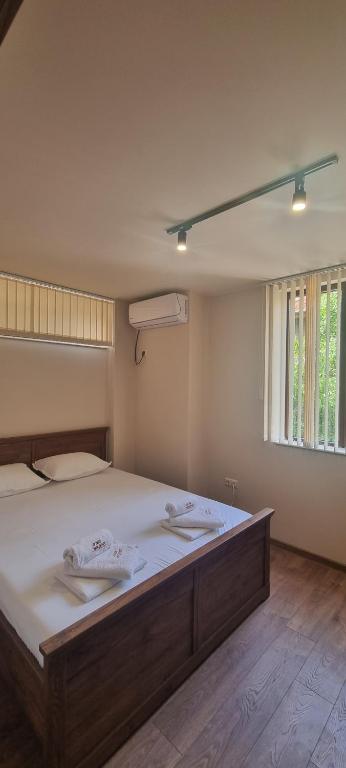 um quarto com uma cama grande e lençóis brancos em Дунав Билдингс 2 em Pleven