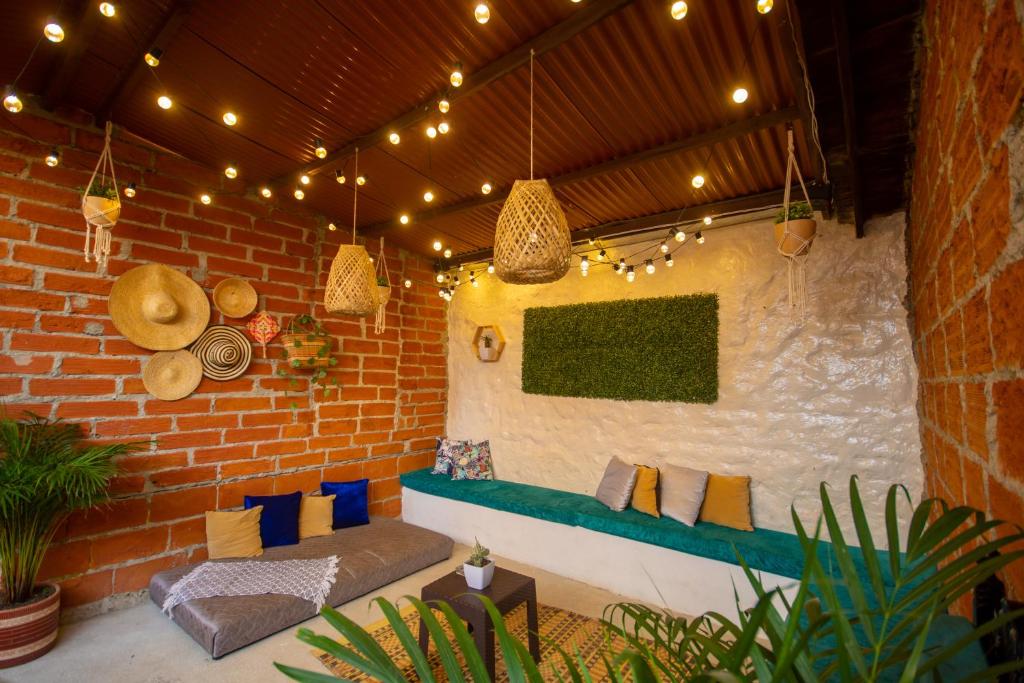 a patio with a couch and a brick wall with lights at Spring Hostel in Medellín