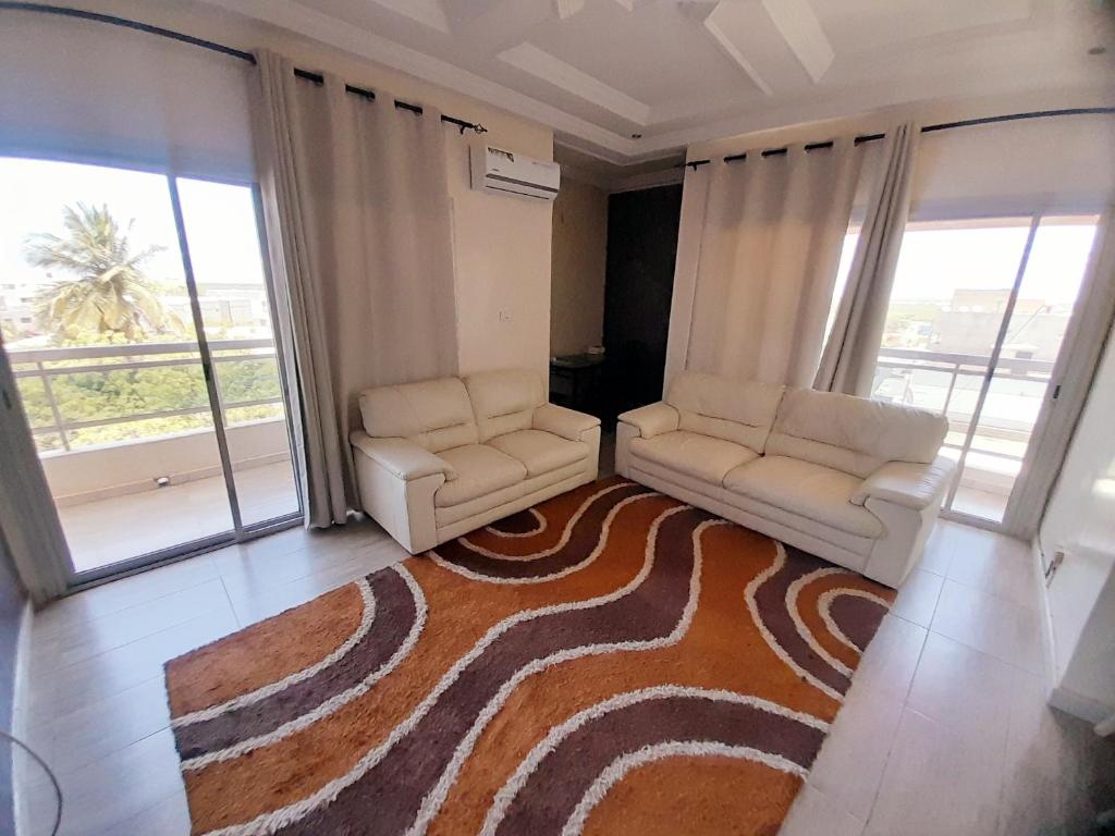 a living room with two chairs and a rug at Appartement deux chambres salon à Saint-Louis in Saint-Louis