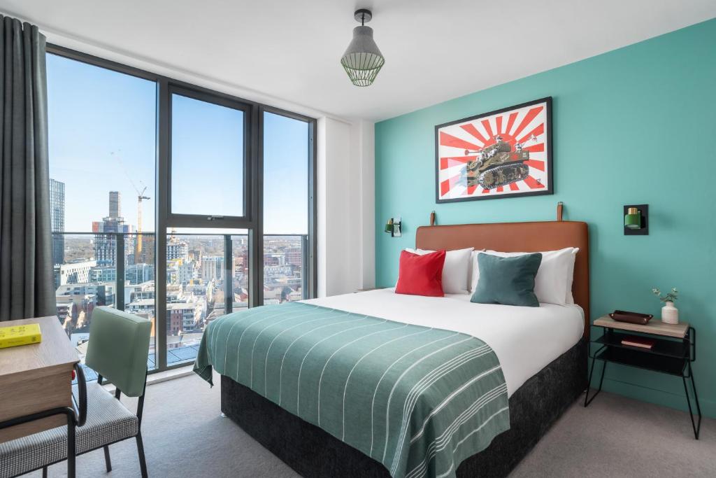 a bedroom with a bed and a large window at Church Street by Supercity Aparthotels in Manchester