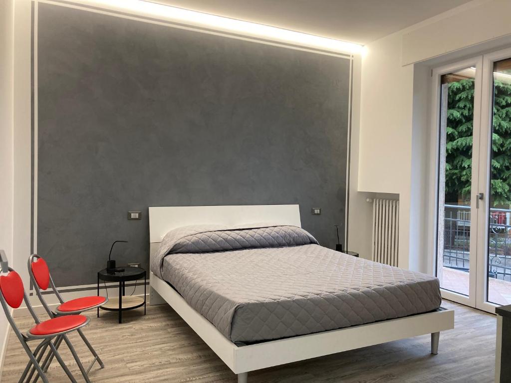 - une chambre avec un lit blanc et des chaises rouges dans l'établissement Garda Art&Lake, à Peschiera del Garda