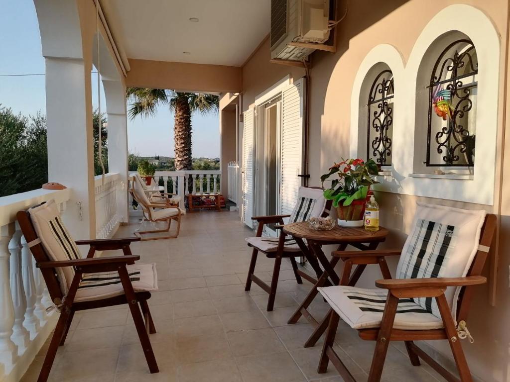 un portico con sedie e un tavolo sul balcone di Villa Katherine Laganas a Vanáton