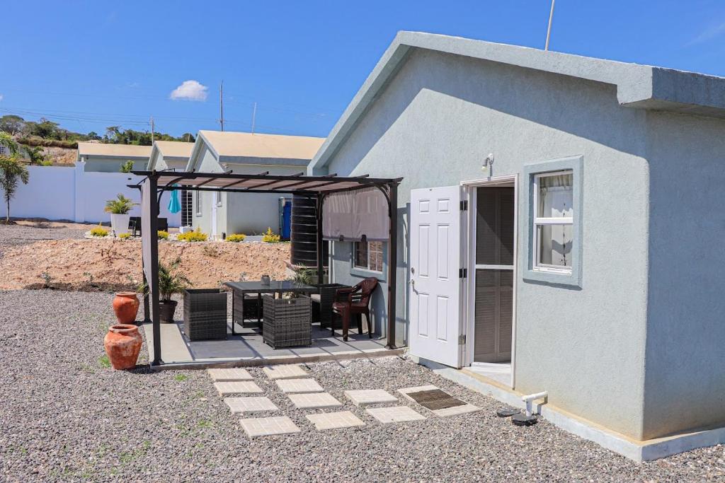 a small house with a patio with a table and chairs at Camelot Paradise in Discovery Bay