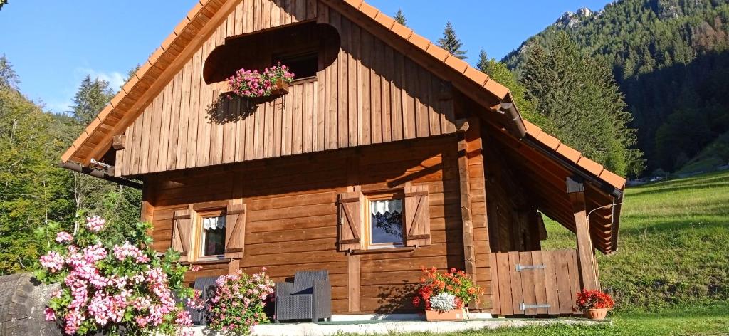 ein Blockhaus mit Blumen davor in der Unterkunft BAITA CIUET in Malborghetto Valbruna