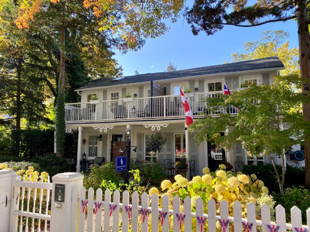 a white picket fence in front of a white house at Harrogate House Inn in Niagara-on-the-Lake