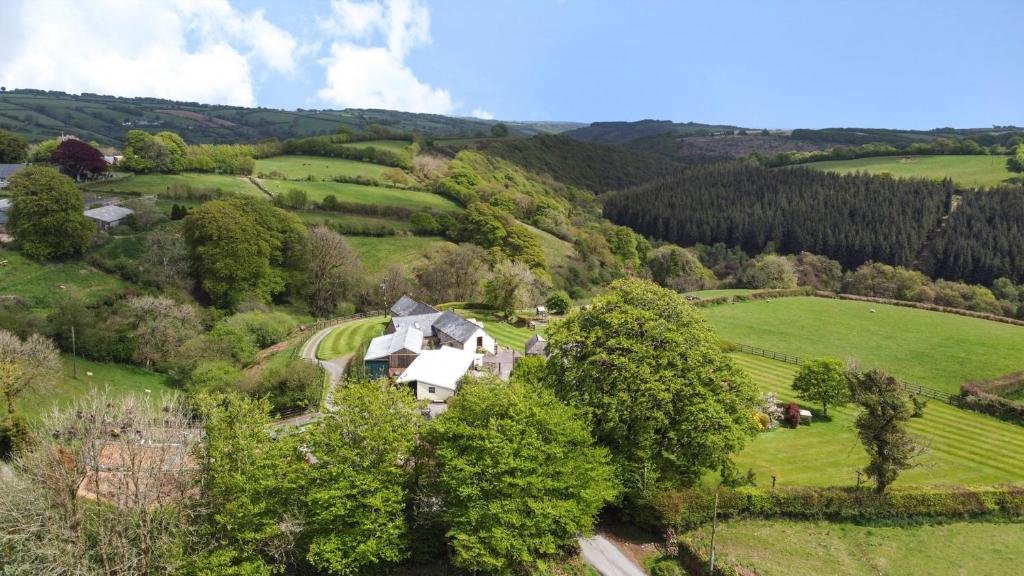 an aerial view of a house in a green field at West Hollowcombe Farm in Dulverton