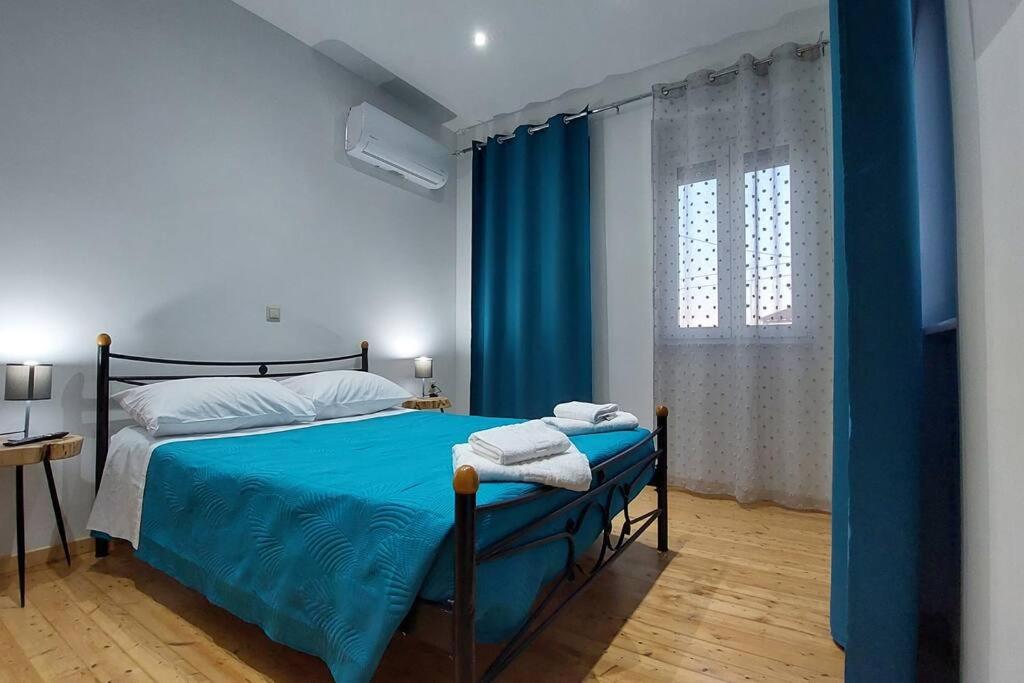 1 dormitorio con cama con sábanas azules y ventana en Palladion house, en Kanálion