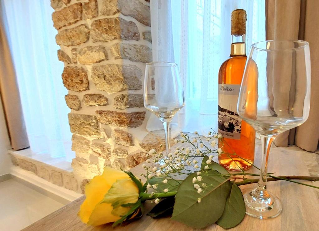 una bottiglia di vino e due bicchieri di vino su un tavolo di Mouses Erato a Vathi