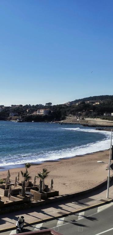 - une plage avec un groupe de chaises et l'océan dans l'établissement La baie d'Agay, à Saint-Raphaël