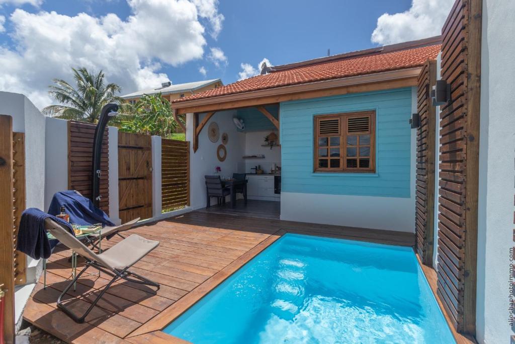 un cortile con piscina e una casa di Bungalow Ti Banane a Sainte-Luce