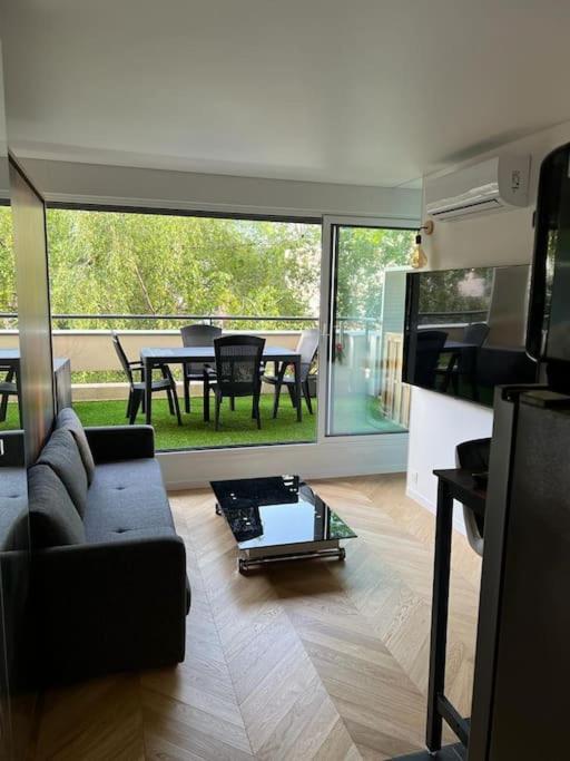 un salon avec un canapé et une table dans l'établissement Studio à La Défense (climatisé, parking), à Courbevoie
