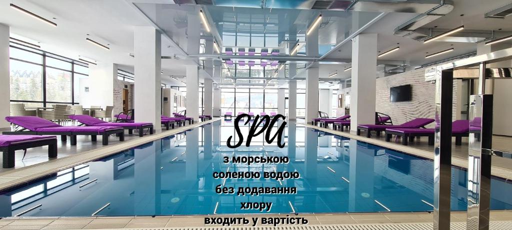 a swimming pool with purple chairs in a building at Kasimir Resort Hotel & SPA in Bukovel