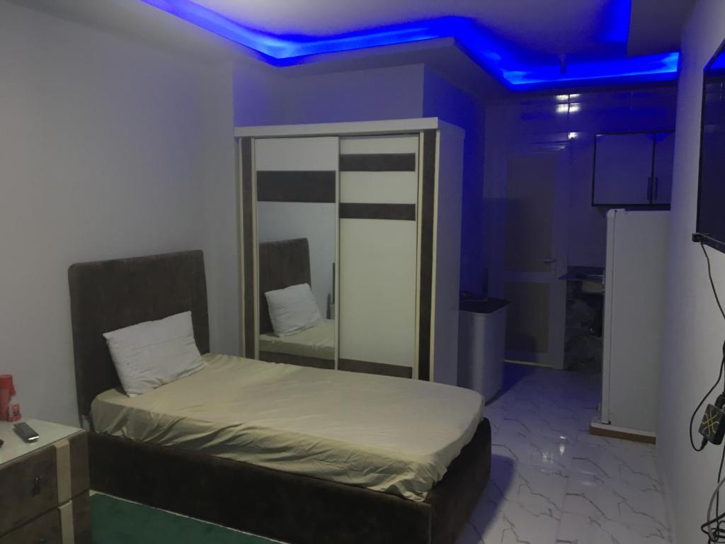 a bedroom with a bed with a blue light at استوديو in 6th Of October
