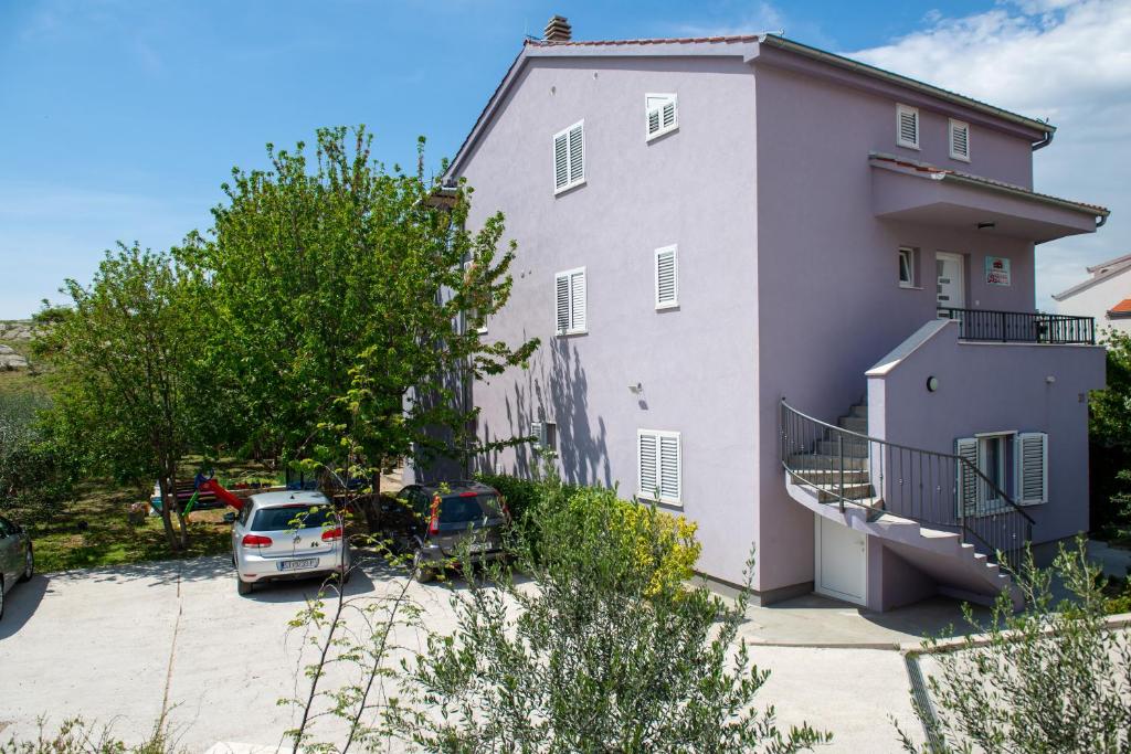 ein weißes Haus mit einem Auto daneben geparkt in der Unterkunft Apartment Fortuna - peacfull terrace in Klis