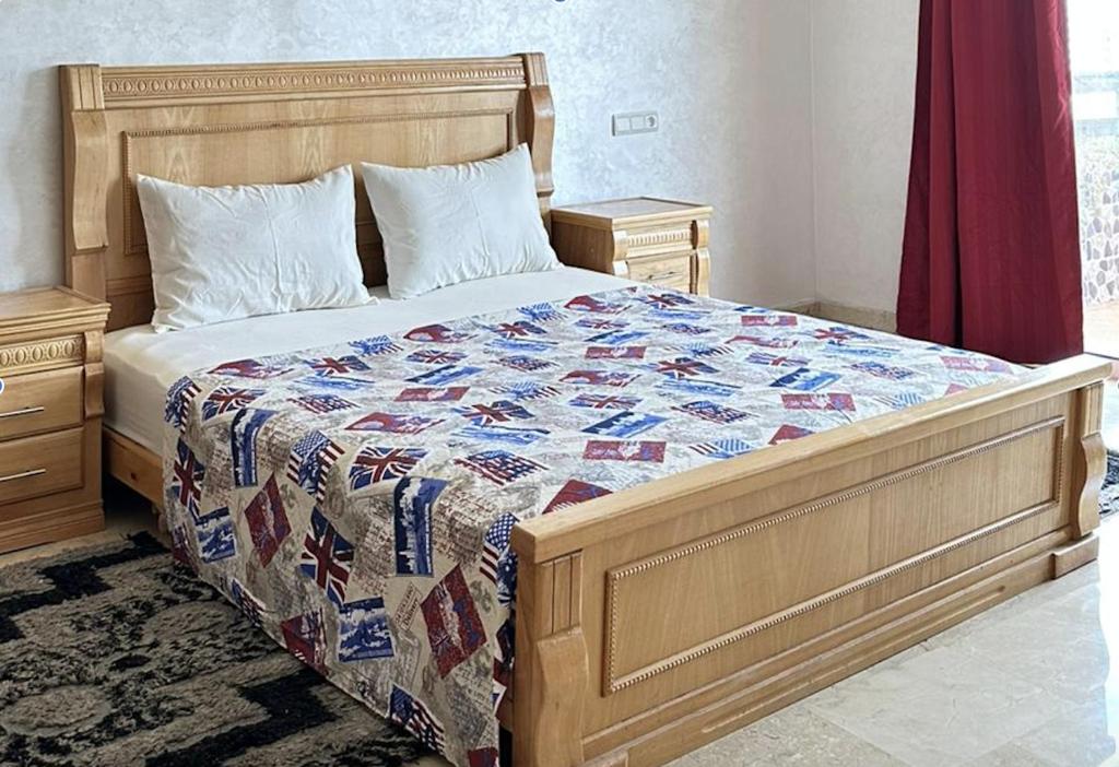 a bed with a quilt on it in a bedroom at Nice Apartment in Marina Agadir in Agadir
