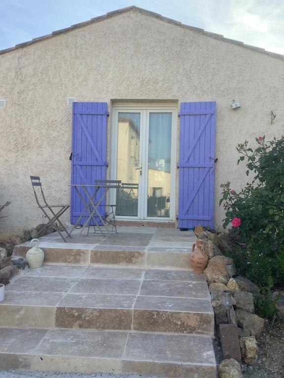Cette maison dispose de portes violettes et d'une terrasse. dans l'établissement Gites de Lyse avec Jacuzzi, à Roujan