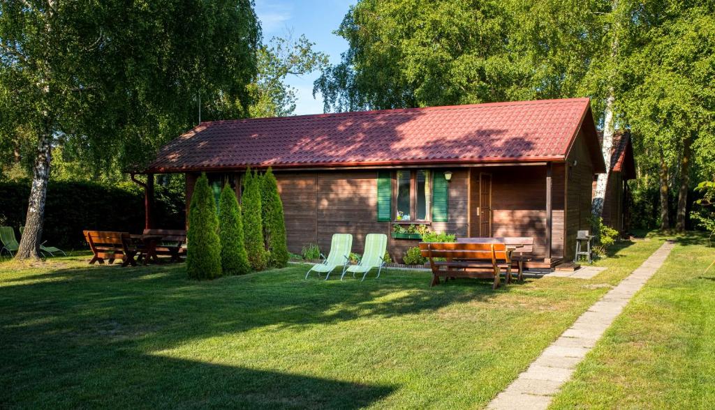 a small cabin with a table and chairs in the yard at DOMKI LUNA in Rowy