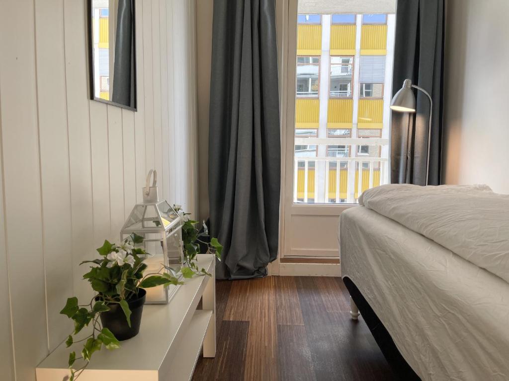 um quarto com uma cama e uma mesa com plantas em City Center Royal Pallace em Oslo