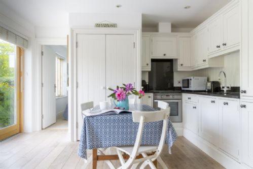a kitchen with a table with a vase of flowers on it at 1 Garden Apartment in Kingsbridge