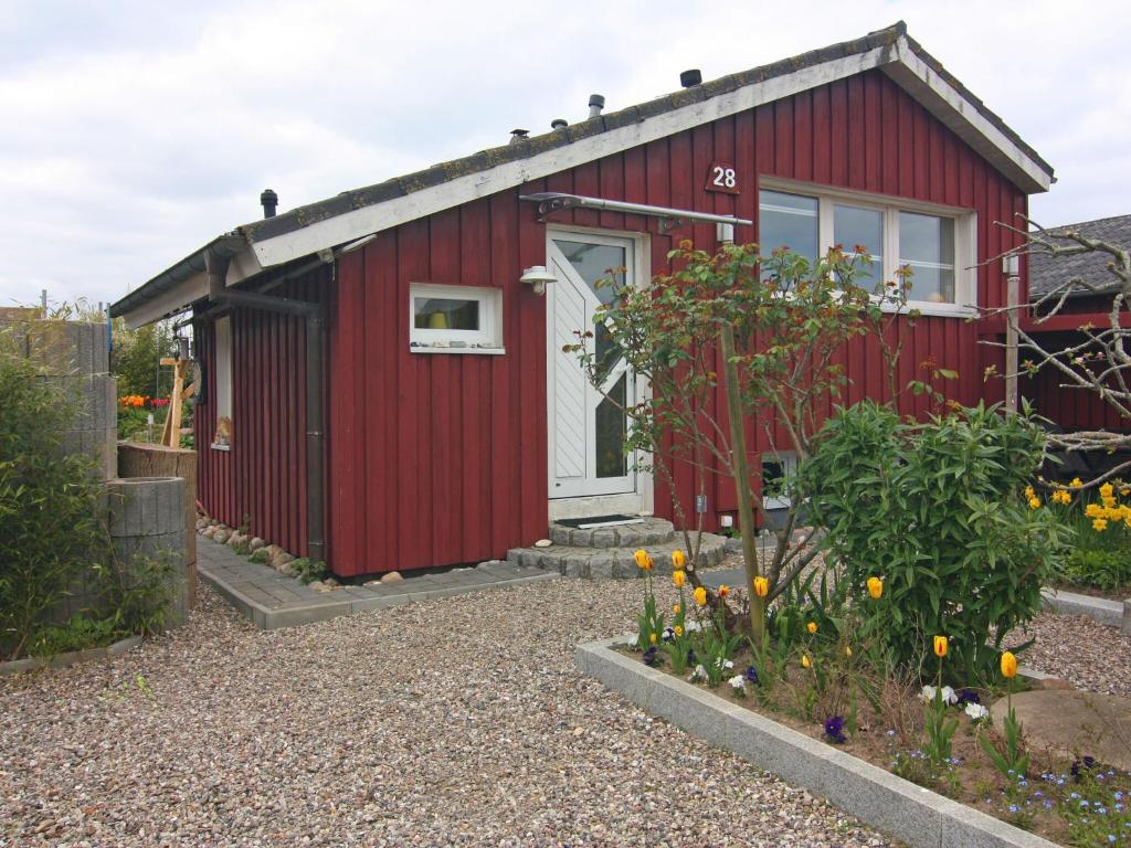 a red shed with a white door in a garden at Cottage, Krusendorf in Krusendorf