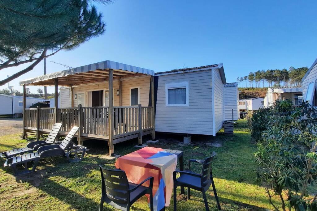 uma pequena casa com uma mesa e cadeiras em Mobil-home Loic camping les Dunes de Contis em Saint-Julien-en-Born