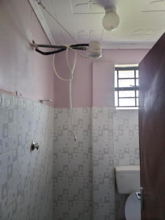 La salle de bains est pourvue d'un ventilateur de plafond et de toilettes. dans l'établissement 3Dee Apartment, Secure with Unlimited Wifi, à Kisumu