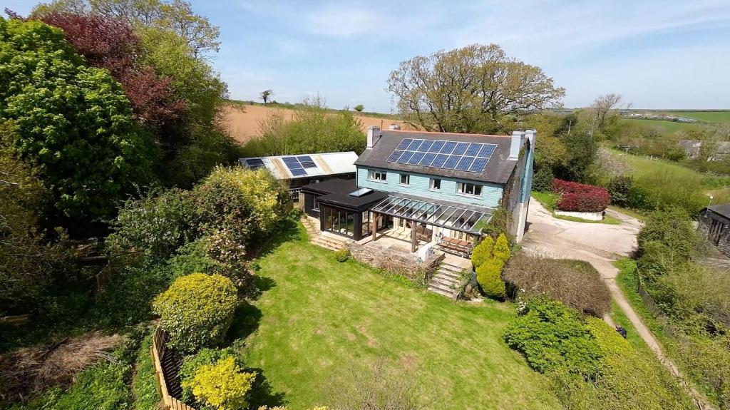 uma vista aérea de uma casa com painéis solares no telhado em Ritson Farm - Large Traditional Farm House em Totnes