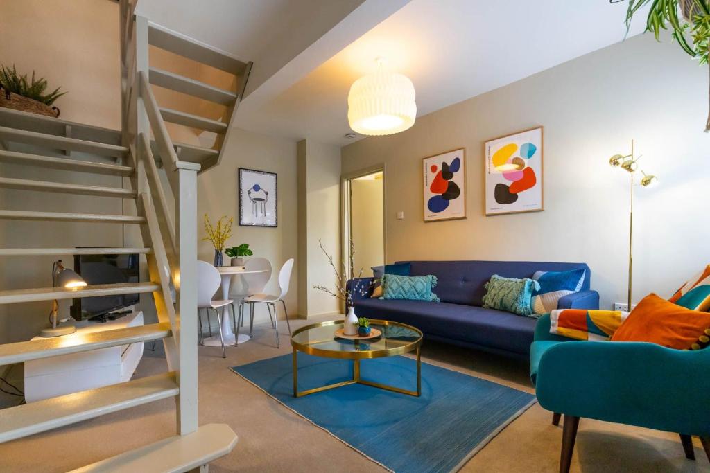 ein Wohnzimmer mit einem blauen Sofa und einem Tisch in der Unterkunft Corner Cottage in Norwich